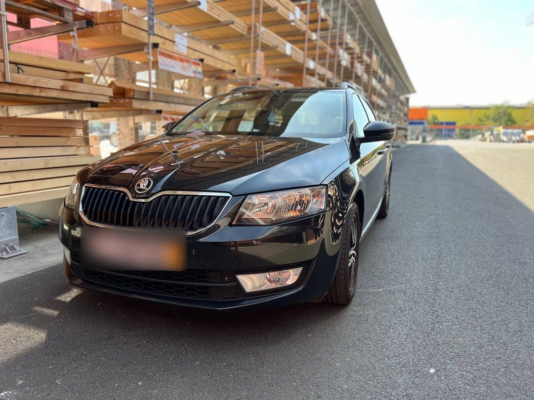 Černá Škoda Octavia Combi před halou stavebnin